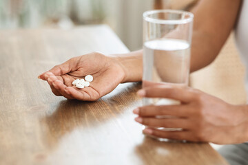 Dietary Supplements. Unrecognizable Black Woman Taking Pills And Drinking Water At Home