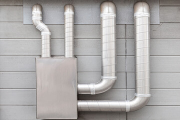 Gray metal fan pipe on buiding wall outside the buidling