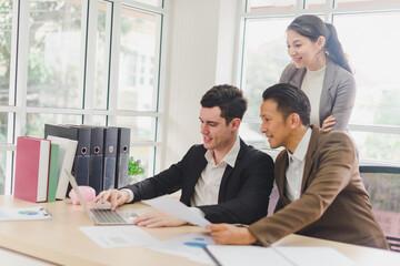 Businessmen are looking at the business plan and business results from the notebook in the office.