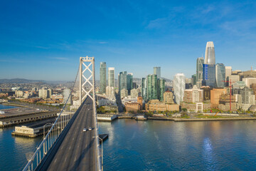 Fototapeta premium Aerial view of the San Francisco, California, skyline at sunrise. Ample copy space in blue sky. Bay bridge in foreground.