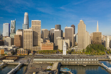 Aerial daytime view of the Embarcadero of the San Francisco, California, skyline. Ferry building in the foreground, ample copy space in blue sky. Morning light.