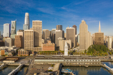 Fototapeta na wymiar Aerial daytime view of the Embarcadero of the San Francisco, California, skyline. Ferry building in the foreground, ample copy space in blue sky. Morning light.