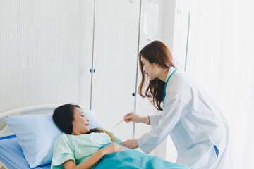 Asian women doctors come to measure the patient's fever. Lying in the patient's bed