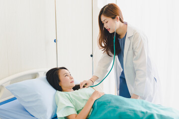 Asian woman doctor examined the patient's breathing stethoscopes. Lying in the patient's bed