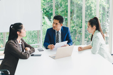 Managers and secretaries meeting and discussing business results from notebooks and paper charging statistics are in the company.