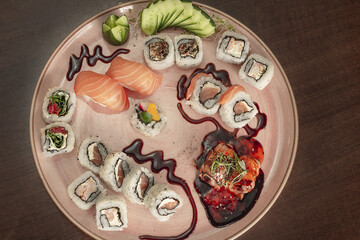 Prato com variedades de sushi (sashimi, salmão flambado, joe, jow, uramaki, niguri e gunka) e molho tarê