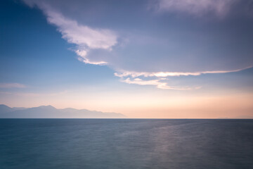 Naklejka na ściany i meble sunset over the sea with big whit cloud on blue sky