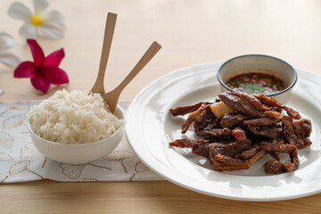 Fried pork with sesame seed and sticky rice on table for breakfast.