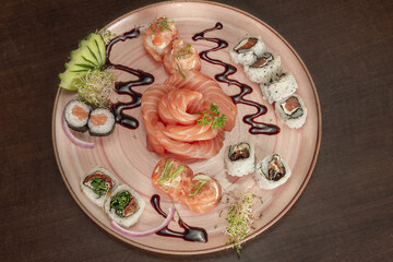 Prato com variedades de sushi (sashimi, salmão flambado, joe, jow, uramaki, niguri e gunka) e molho tarê