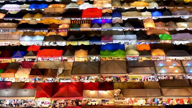 Ratchada Rot Foi Train night market in Bangkok, Thailand with rows of colourful tents stalls seen at night