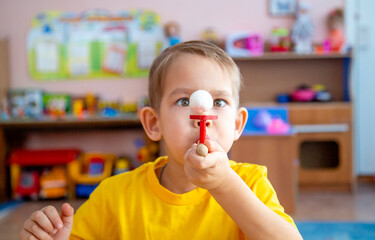 The little boy in the classroom with the speech therapist . The use of special tools for speech...