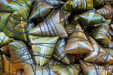 Heap of ZhongZi - traditional Chinese rice dish made of glutinous rice stuffed and wrapped in bamboo leaves in a street market, Chengdu, Sichuan province, China
