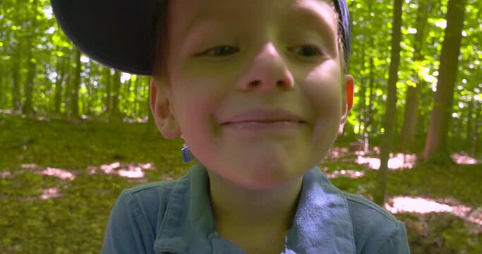 Outdoor portrait of a smiling little boy missing his front teeth.