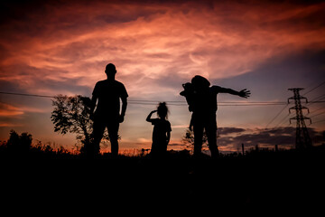 Happy family, father, mother, son and daughter in nature, sunset