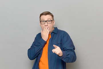 Shot of shocked frightened man pointing with finger at something awful