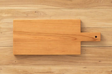 Handmade long cherry wood chopping board on elm table top.