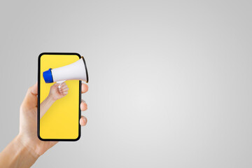 Business Communication and Marketing Concept : Hand holding megaphone in smartphone for...