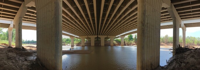 Underneath a bridge support structure. Bridge over river. 