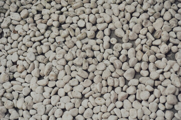 white pebbles stone texture background. Naturally polished white rock pebbles background
