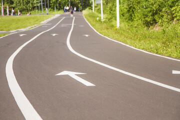 Obraz premium White forward arrow to finish on running track. Asphalt walk way in park. Stock photography.