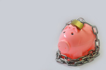 Fototapeta premium piggy bank locked using chain and lock with some parts in focus