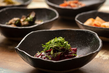 asian fermented kimchi fermented food beet on a black bowl and other ingredients on background