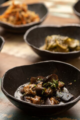 asian fermented kimchi fermented food eggplant on a black bowl and other ingredients on background