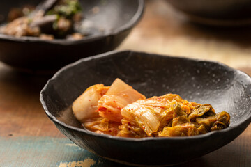 asian fermented kimchi fermented food cabbage on a black bowl and other ingredients on background