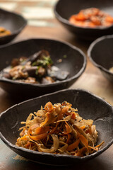 asian fermented kimchi fermented food cabbage on a black bowl and other ingredients on background