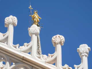 Obraz premium Milano, Italy. The spires of white marble that adorn the entire cathedral. In the background the famous Madonnina on the highest part of the Duomo, a statue of the Virgin Mary