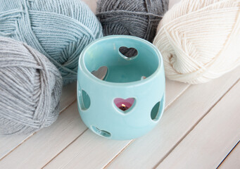 Wool yarn milky, gray, mint color lie on a light wooden table