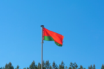 Belarusian national flag on a background of daytime blue sky