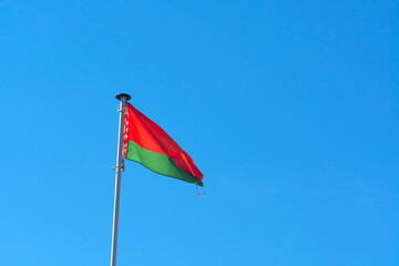 Belarusian national flag on a background of daytime blue sky