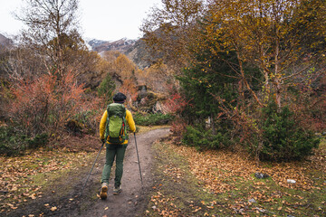 Obraz premium Young Asian trekker with backpack walking on beautiful trail in Manaslu circuit trekking route in autumn season, Himalaya mountains range in Nepal