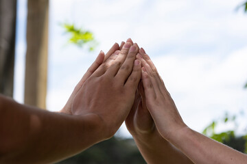 hands together outside forming a symbol of fate teamwork bonding group of people