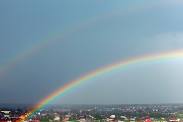 Double rainbow over the city in a fine rain.