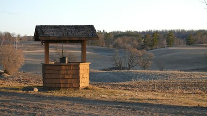 Time-lapse of stone water well with roof at sunrise