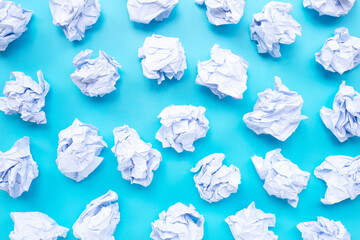 White crumpled paper balls on a blue background.