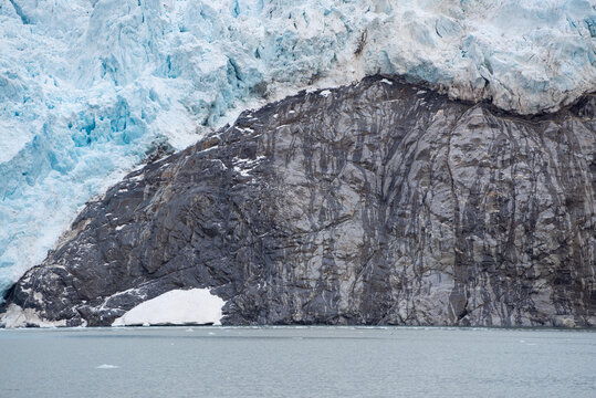 Melting glacier on Spitsbergen with a rock getting free and visible.