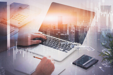 Man typing on laptop, financial chart