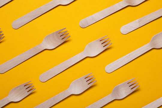 Disposable Wooden Forks On Yellow Background. Single Use Biodegradable Eco-friendly Disposable Utensils