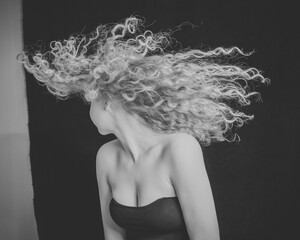 Romantic girl with curly long hair. Black and white portrait.