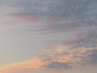 Fototapeta na wymiar 薄っすらピンク色に染まる夕焼け空の雲