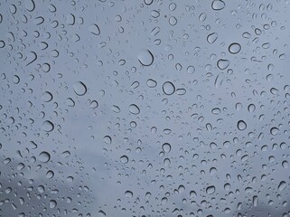 Random raindrops water bubbles beads drizzling Transparent on the Glass Window After Rainy Day.