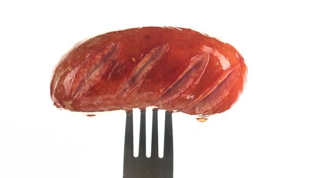 grilled sausage on fork white background