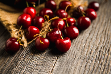 Fototapeta na wymiar Ripe and juicy cherries on the dark rustic background. Selective focus. Shallow depth of field. 