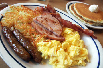 Full American Breakfast with sausage, ham, scambled egg, pancake and hash brown, served on oval...