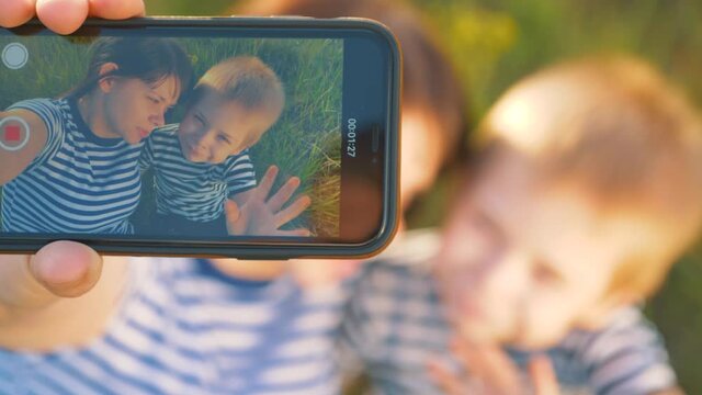 Happy family mom and son take selfie using smartphone. The family smiles, has fun, takes photos and communicates online with friends.