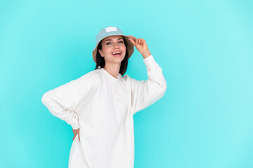 White t-shirt . Beautiful girl model in white hoody in hat on a blue background