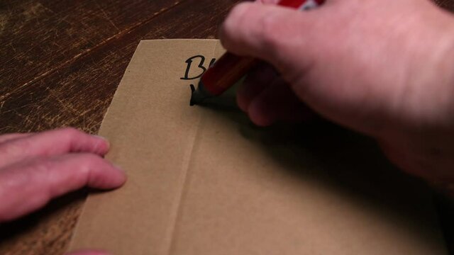 Writing on a protestors place card black lives matter in reverse.